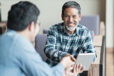 Man Smiling Looking at Tablet